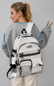 Detailansicht eines cremeweißen Rucksacks mit mehreren Taschen und Kaninchenanhänger