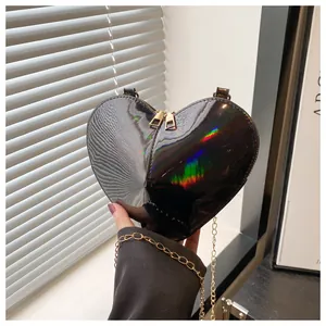 Macro view of heart-shaped laser bag showing black iridescent texture and gold chain detail