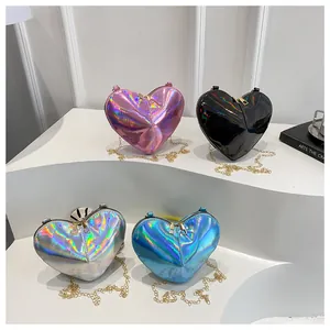 Detail of four holographic heart chain bags in pink, black, silver, and blue tones