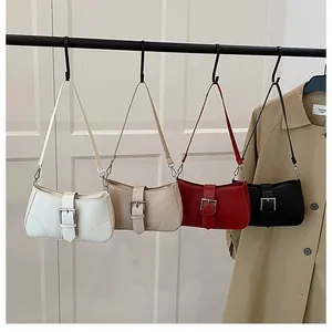 Detailed display of crescent bags in four colors hanging on a black metal rack