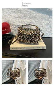 Detail showing the brown leopard print pattern and glossy patent leather texture of the handbag
