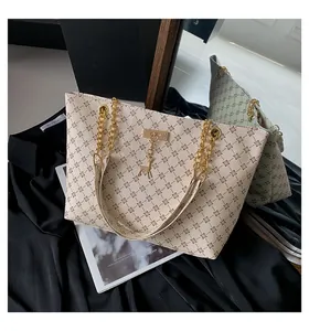Close-up of retro tote bag with brown geometric pattern and golden deer charm detail