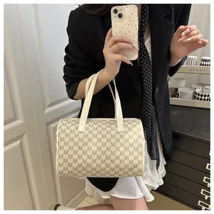 Close-up of beige Boston bag featuring monogram print and elegant leather handles
