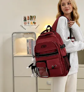 Detailansicht des dunkelroten Canvas-Rucksacks mit vielen Taschen und süßem Anhänger