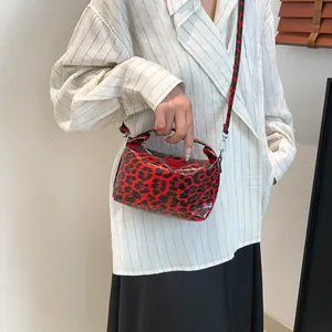 Red and black leopard print patent leather handbag with adjustable crossbody shoulder strap