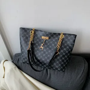Fashionable tote bag with geometric pattern, chain strap, and golden deer charm detail