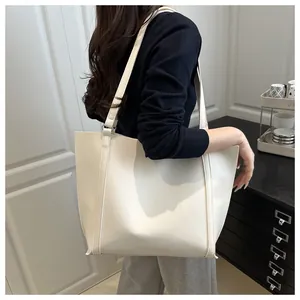 Minimalist beige leather tote bag displayed on model for high-end urban fashion style