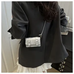 Détail du mini sac à bandoulière argenté avec finition métallique texturée et double boucle