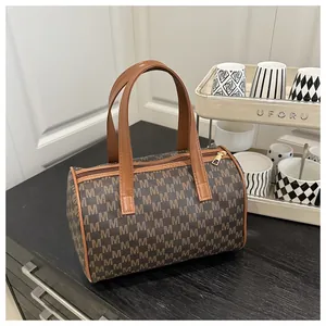 Close-up of vintage Boston handbag featuring brown monogram pattern and golden hardware