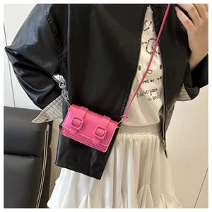 Détail du mini sac à bandoulière rose fuchsia avec doubles boucles et texture croisée