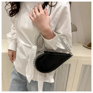Detailansicht einer schwarzen asymmetrischen Herz-Handtasche mit funkelnden Strasssteinen