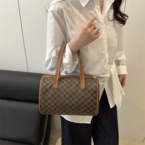 Classic Boston handbag with brown M-letter pattern shown in a minimalist lifestyle setting
