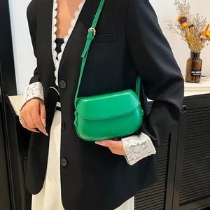 Close-up of vibrant green saddle bag on a model featuring a smooth semi-circle design