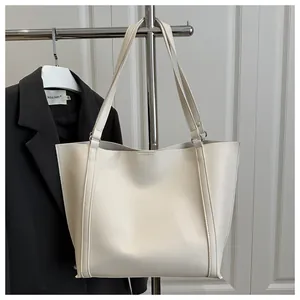 Minimalist cream white tote bag in high-quality PU leather shown hanging on a stand