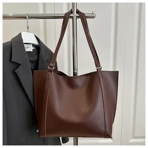 Detail of vintage brown tote bag showing dual shoulder straps and matte PU leather texture