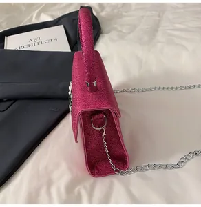 Detail of rose red glitter texture on handbag with silver chain and side gusset