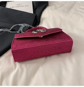 Detailed view of the sparkling sequin fabric and silver bow clasp on the pink crossbody bag