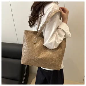 Detailed view of khaki woven leather tote bag texture with silver rivets and shoulder straps