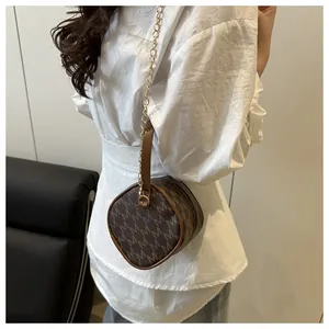 Détail du mini sac cylindrique pour femme avec motif logo marron et bandoulière chaîne