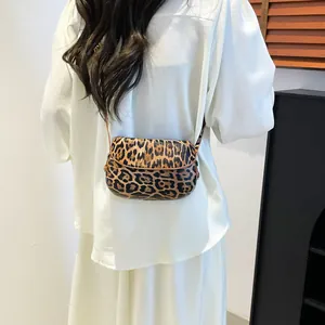 Detail view of stylish leopard print saddle bag with slim brown shoulder strap and PU texture
