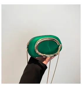 Vue détaillée du sac vert avec un grand anneau en métal doré et une bandoulière en chaîne