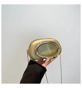 Détail de la pochette champagne doré avec boucle ovale et bandoulière en chaîne fine