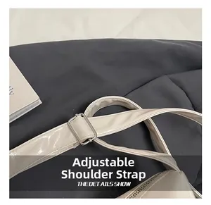 Detail showing the adjustable beige leather shoulder strap with a silver metal buckle