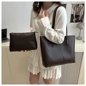 Detail of dark brown leather tote bag set with vertical stitching and matching pouch