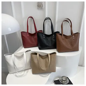 Detailed group shot of large woven tote bags in five colors on a geometric stand