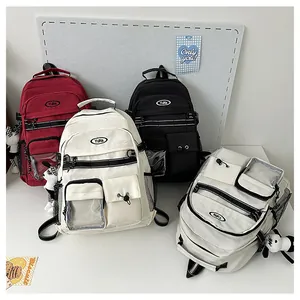 Dettaglio di zaini scolastici colorati con tasche multiple e ciondoli graziosi