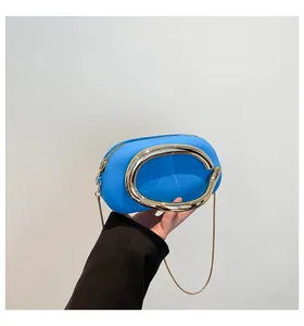 Détail du sac en cuir bleu avec grand anneau doré et bandoulière chaîne chic