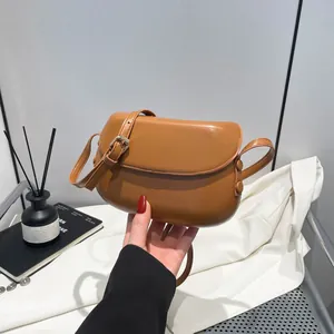 Detail view of a vintage brown saddle bag with adjustable buckle strap and high-end PU texture
