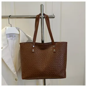 Detail of woven texture and reinforced shoulder straps on brown retro tote bag