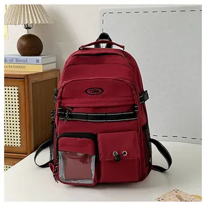 Dettaglio dello zaino in nylon bordeaux con ricamo Yuna e tasca frontale trasparente