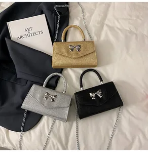 Three glitter mini flap bags in gold silver and black with metal bow clasp and chain straps