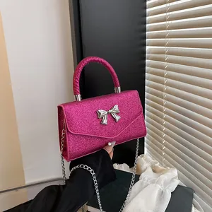 Chic magenta glitter crossbody bag with silver bow accent and elegant metal chain strap