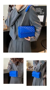 Detail der blauen Stepptasche mit silberner Kette, getragen zu einem grauen Anzug