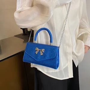 Sparkly blue crossbody bag with silver metal bow and chain strap for summer fashion