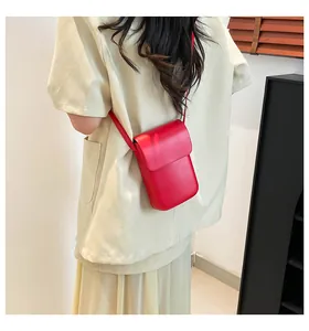 Detailed back view of a minimalist bright red crossbody phone bag on a model