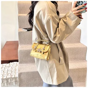 Dettaglio mini borsa a tracolla metallizzata oro con chiusura a stella e tracolla a catena
