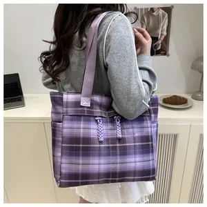 Detail of purple plaid tote bag with woven drawstrings and high-density fabric texture