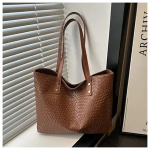 Detail of a brown woven texture tote bag with metallic studs on a sunny window background
