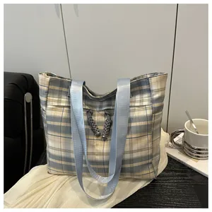 Detail view of plaid tote bag featuring blue yellow patterns and rope knot detail