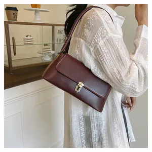 Fashionable dark red baguette bag with silver clasp styled in a café setting