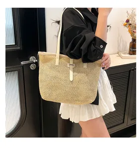Elegante borsa tote in paglia intrecciata con spalline in pelle color crema indossata