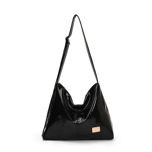 Minimalist black glossy hobo shoulder bag with adjustable strap and gold logo plate