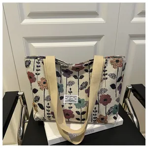 Detail of vintage floral canvas tote bag with tapestry print on a black leather chair