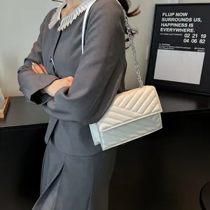 Elegante weiße Stepptasche mit silberner Kette kombiniert zum grauen Damenblazer