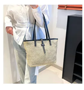 Dettaglio della borsa tote intrecciata con tracolla in pelle nera e fibbia