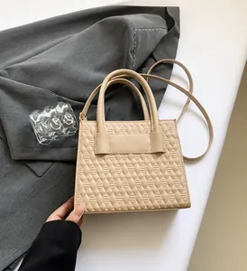 Detail der beigen gesteppten Handtasche mit eleganter Lederschleife und Rautenmuster